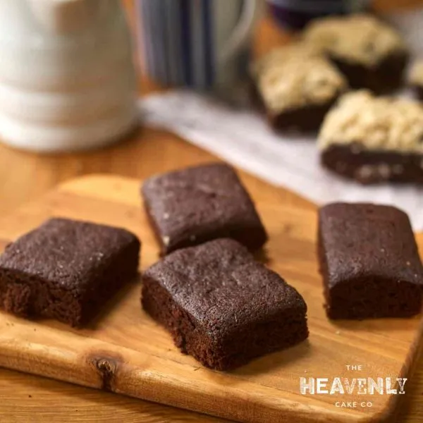 Chunky gluten free brownies displayed on a wooden chopping board